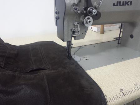 Naaimachine die een kledingstuk stikt