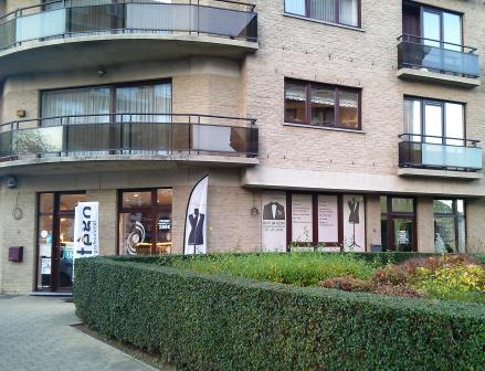 Buitenkant van de zaak, met uistaande vlag met modepop