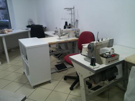 Werkplaats met verschillende garens,een werktafel en stoel.