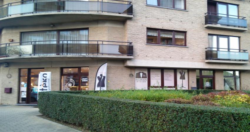 Buitenkant van de zaak, met uistaande vlag met modepop